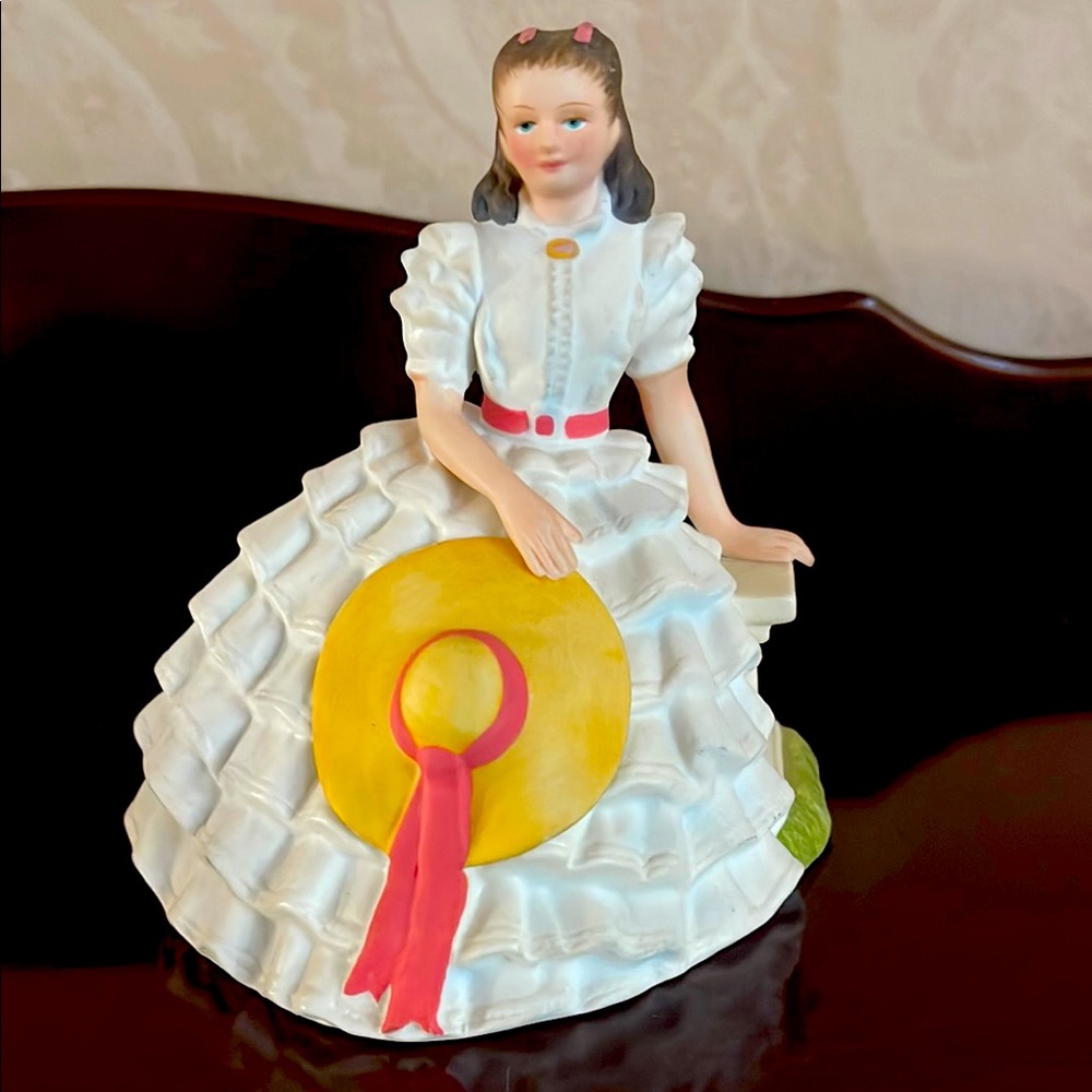 Porcelain Figurine with Yellow Hat and Pink Ribbon